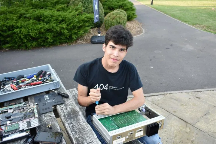 Boy disassembling electronics in 'reverse engineering' session at Tech Camp