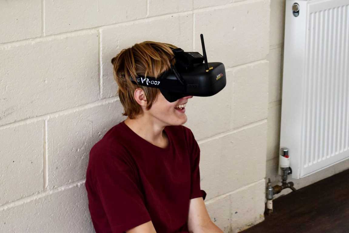 Camper with VR glasses steering the remote-control car he has built