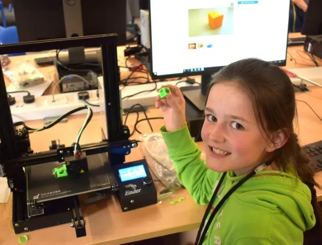 Girl proudly showing the 3D printer she has built at Tech Camp