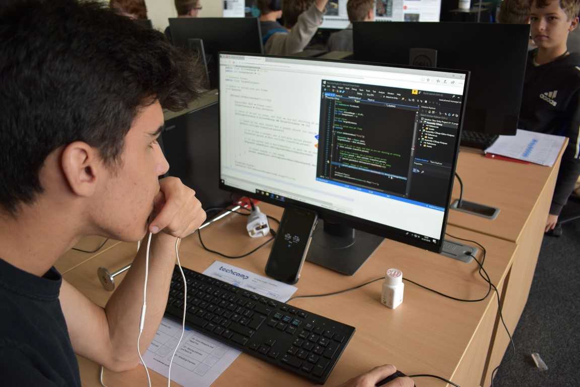 Teen boy in front of computer screen working on his VR game design